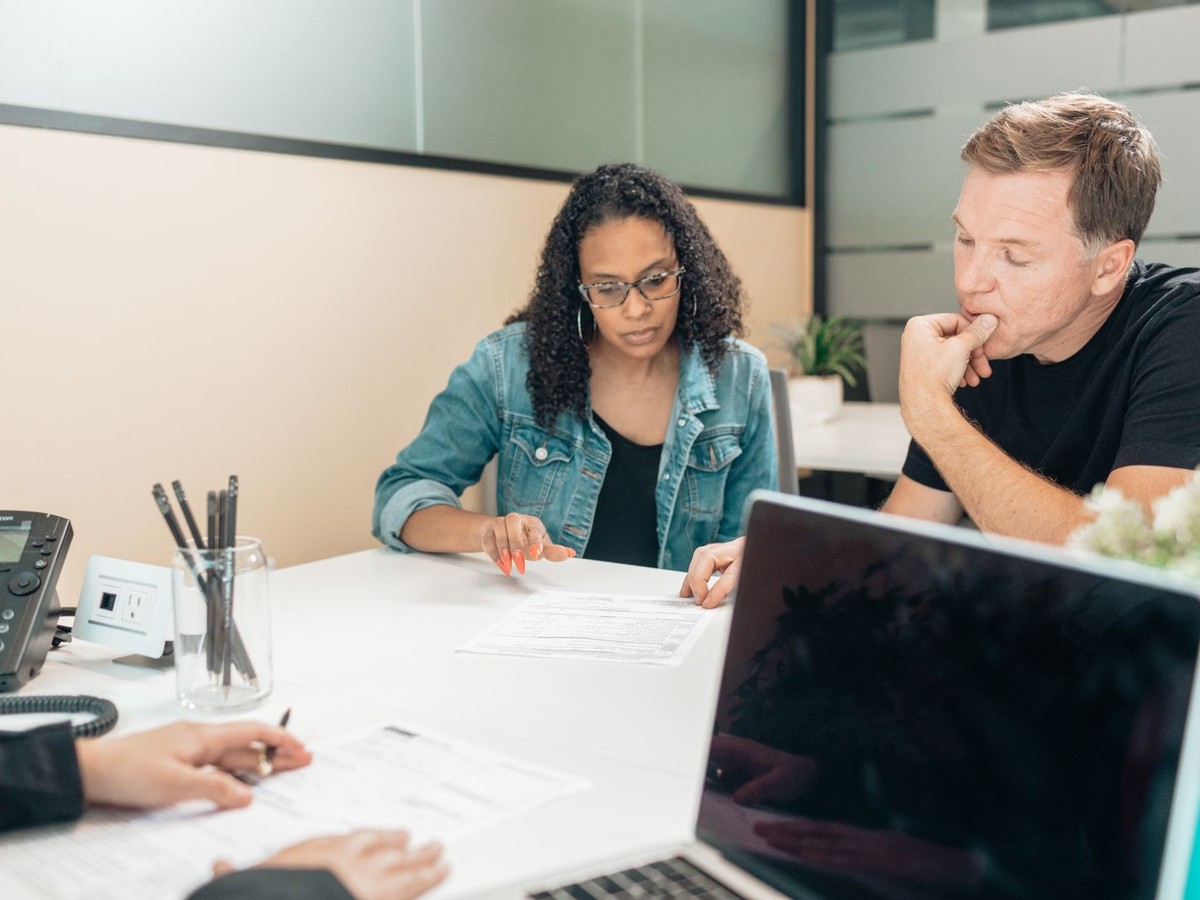 Couple reviewing documents with an adviser